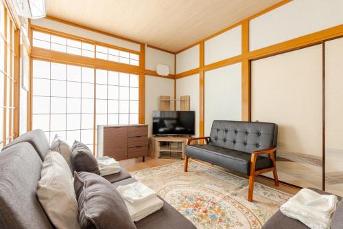a living room with a couch and a tv at Fukurou House in Tokyo