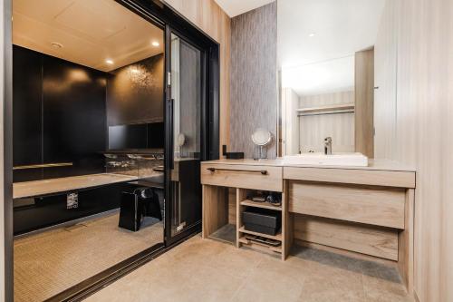a bathroom with a sink and a mirror at Stadium City Hotel Nagasaki in Nagasaki
