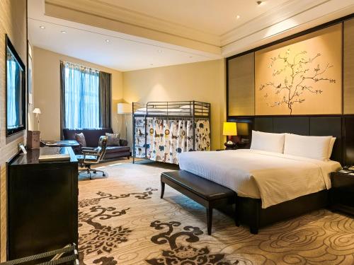 a hotel room with a bed and a chair at Wyndham Grand Xi'an South in Xi'an