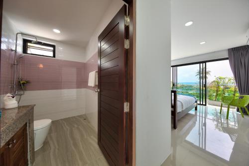 a bathroom with a toilet and a bed and a window at Villa Jasmin - Popular 4 Bed Pool Villa in Lamai