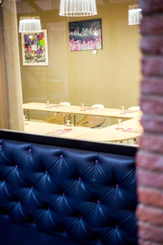 a meeting room with tables and a blue couch at Grand Hôtel d'Orléans in Toulouse