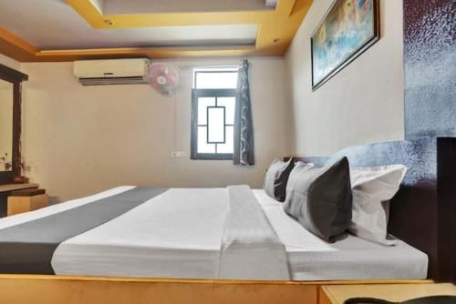 a bedroom with a large white bed with a window at Hotel Phool Plaza in Kota