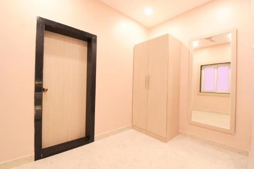 an empty room with a door and a mirror at Hotel Sai Swastik in Puri