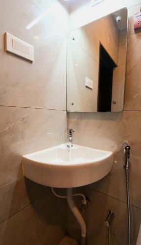 a sink in a bathroom with a mirror at Hotel Sai Swastik in Puri