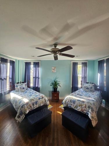 a bedroom with two beds and a ceiling fan at Birmingham's Spacious Uptown Family Retreat in Birmingham