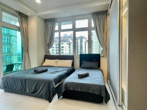 a bedroom with two beds in front of a window at Kuching City Center Riverine Apartment With Balcony and Garden View in Kuching