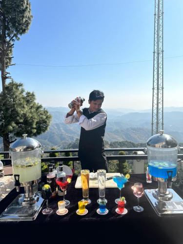 a man taking a picture of a table of drinks at Peaks And Pines Resort in Lansdowne