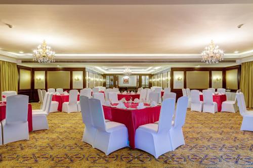 a banquet room with red and white tables and white chairs at Ramada Plaza By Wyndham, Chandigarh Zirakpur in Chandīgarh