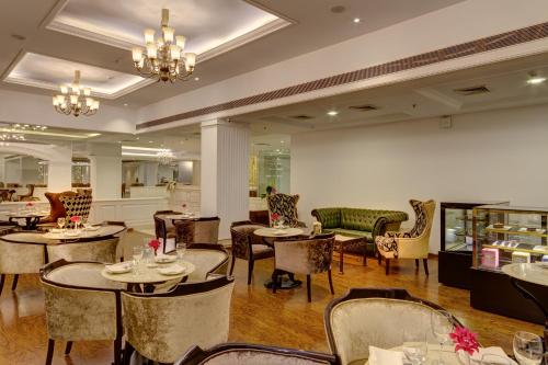 a restaurant with tables and chairs in a room at Ramada Plaza By Wyndham, Chandigarh Zirakpur in Chandīgarh
