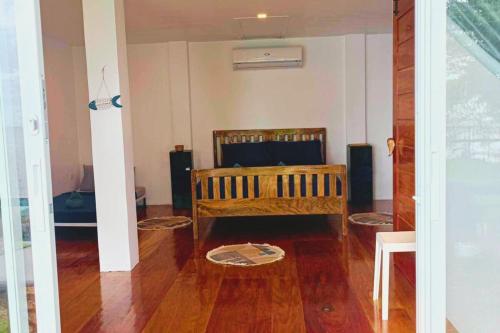 a living room with a bed and a wooden floor at Txaleta de Camiguin desde 2024 in Mambajao