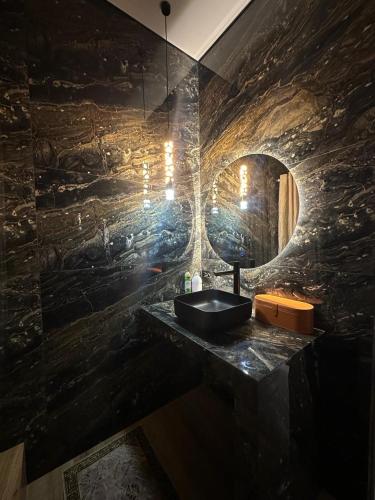 ein Badezimmer mit einem Waschbecken und einer Steinmauer in der Unterkunft Двухкомнатная квартира в жилом доме ЖК Арман/ One-bedroom apartment in Arman residential complex in Atyrau