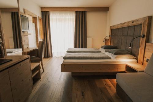 a bedroom with a large bed with a wooden headboard at Pension Moarhof in Feldthurns