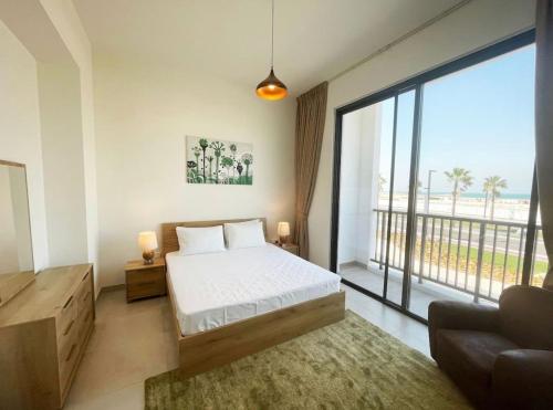 a bedroom with a bed and a large window at RAKvista Residence in Ras al Khaimah