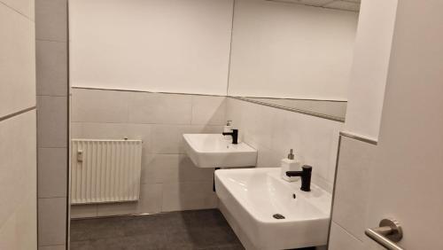 a white bathroom with a sink and a mirror at Zimmer A in Mönchengladbach