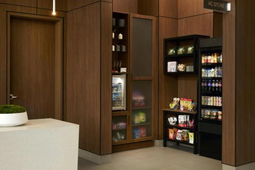 a kitchen with a refrigerator and shelves with drinks at AC Hotel Seattle Downtown in Seattle