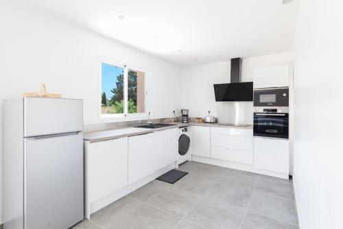 La cuisine blanche est équipée d'un évier et d'un réfrigérateur. dans l'établissement 