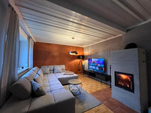 a living room with a couch and a fireplace at Stay Nice Thermen-Glück 3BR 100qm Whirlpool-Badewanne in Bad Aibling