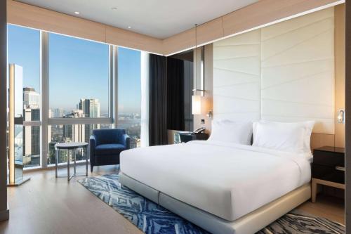 a bedroom with a white bed and a large window at Wyndham Grand Istanbul Levent Hotel & Conference Center in Istanbul