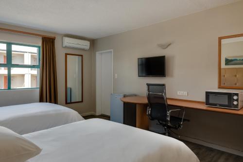 a hotel room with two beds and a desk at Protea Hotel by Marriott Cape Town Tyger Valley in Bellville