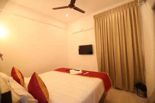 a hotel room with two beds and a ceiling fan at J Park Auroville Beach in Kottakupam