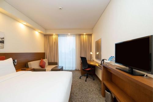 a hotel room with a bed and a desk with a television at Hampton by Hilton Samsun in Samsun