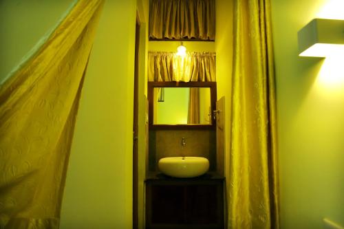 a bathroom with a sink and a mirror at Snow Hills Resorts in Thekkady