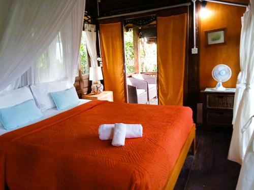 a bedroom with a bed with two towels on it at Pondok Pisces Bungalows Balian Beach in Selemadeg
