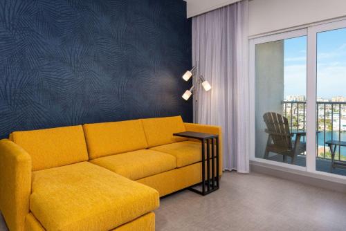 a living room with a yellow couch and a table at Hampton Inn and Suites Clearwater Beach in Clearwater Beach