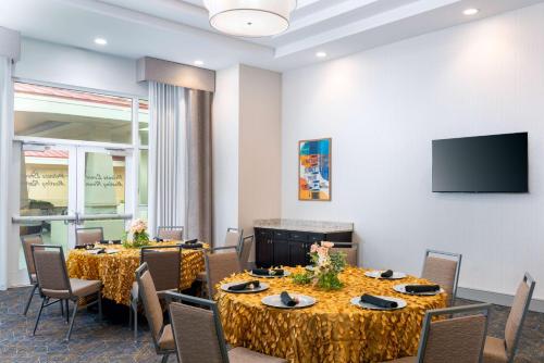 a conference room with tables and chairs and a flat screen tv at Hampton Inn and Suites Clearwater Beach in Clearwater Beach