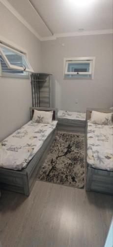 a room with two beds and a rug at Oltin Vodiy hostel in Fergana