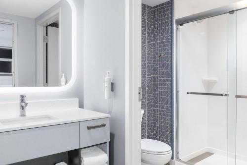 a white bathroom with a shower and a toilet at Homewood Suites By Hilton Holland in Holland