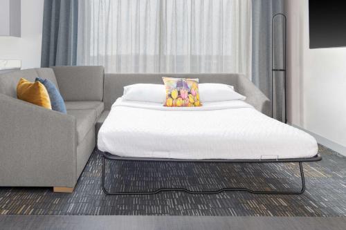 a bed in a room next to a couch at Homewood Suites By Hilton Holland in Holland