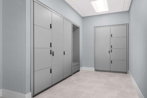 a locker room with white cabinets and a door at Homewood Suites By Hilton Holland in Holland