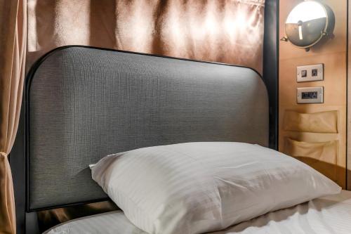 a bed with a black headboard and a white pillow at Getcha Hostel in Taichung