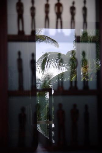 a view of a palm tree through a window at Boracay Beach Houses in Boracay