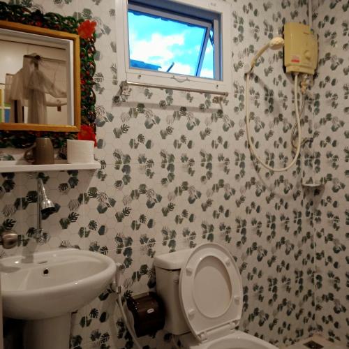 a bathroom with a toilet and a sink and a shower at บ้านจัสมิน in Sukhothai