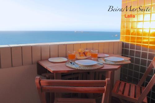 a table with plates and glasses of orange juice on a balcony at Beira Mar Suite in Fortaleza
