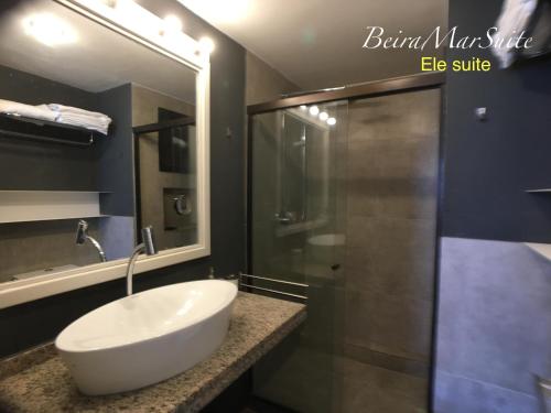 a bathroom with a sink and a shower at Beira Mar Suite in Fortaleza