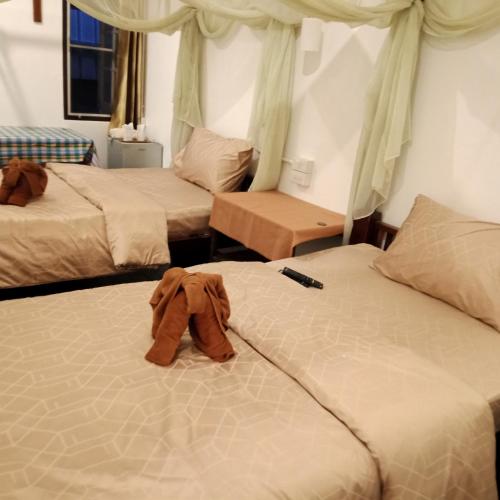 two beds in a hotel room with a shirt on them at บ้านจัสมิน in Sukhothai