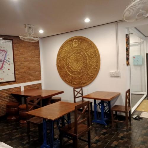a room with tables and a large shield on the wall at บ้านจัสมิน in Sukhothai