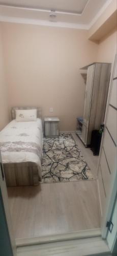 a bedroom with a bed and a rug at Oltin Vodiy hostel in Fergana