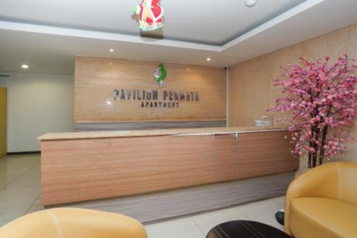 a hotel lobby with a reception desk and flowers at Pavilion Permata Hotel Manage By Occupied in Surabaya