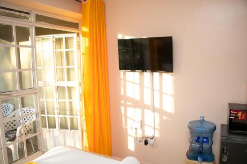 a room with a flat screen tv on a wall at Amani Place in Ruaka