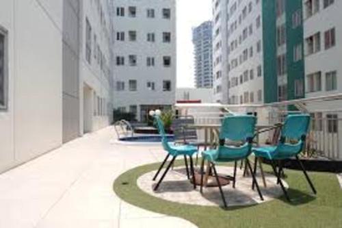 a group of chairs and a table on a balcony at Pavilion Permata Hotel Manage By Occupied in Surabaya
