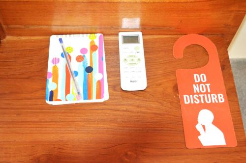 a remote control and a do not disturb sign on a table at Madiha Venus in Matara