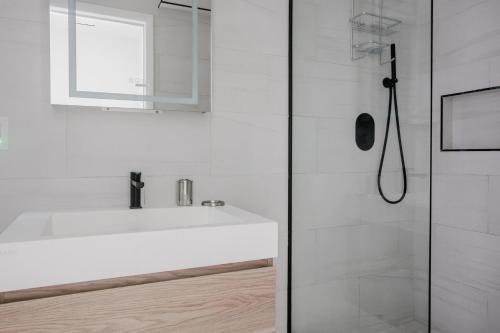 a white bathroom with a sink and a shower at Blueground Upper East Side AC wd nr park NYC-1747 in New York