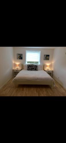 a bedroom with a large bed with two tables at Modern & Spacious apartment in Silkeborg