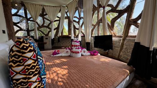 a bedroom with a bed with two stuffed animals on it at The Nest Tropical Oasis Resort in Paje