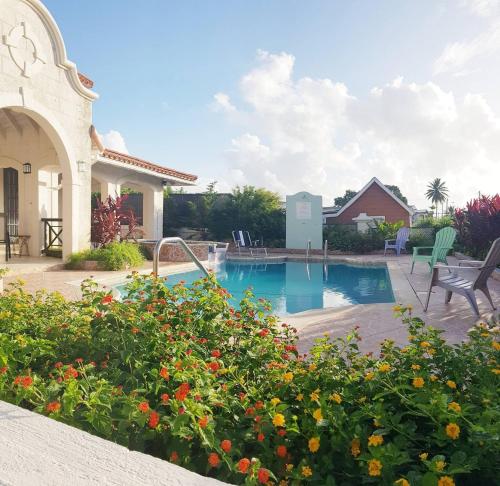 une maison avec une piscine dans une cour dans l'établissement Jackson Breezy Vacation and Venue Rental Barbados, à Saint Michael