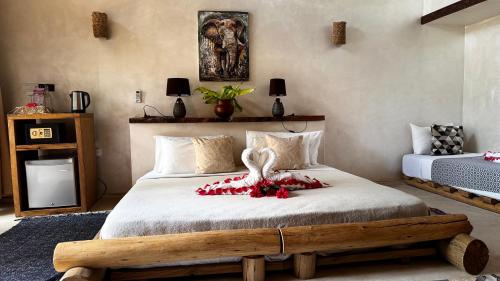 a bedroom with a large bed with a wooden frame at The Nest Tropical Oasis Resort in Paje